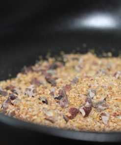 Mélange de grains et de graines dans un récipient noir, utilisé pour la cuisine ou la décoration.